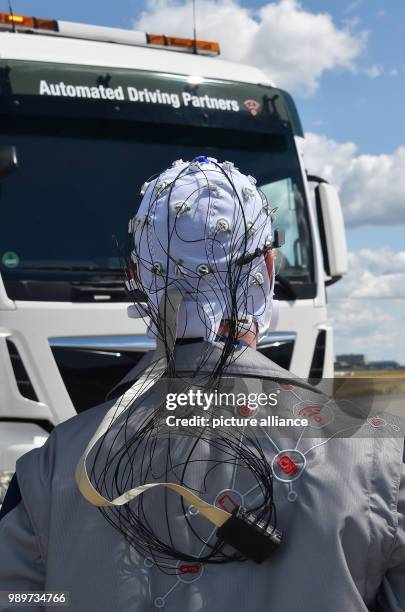 July 2018, Germany, Selchow: Truck driver Andy Kipping wearing a control system with which - with the aid of electroencephalography and eye tracking...