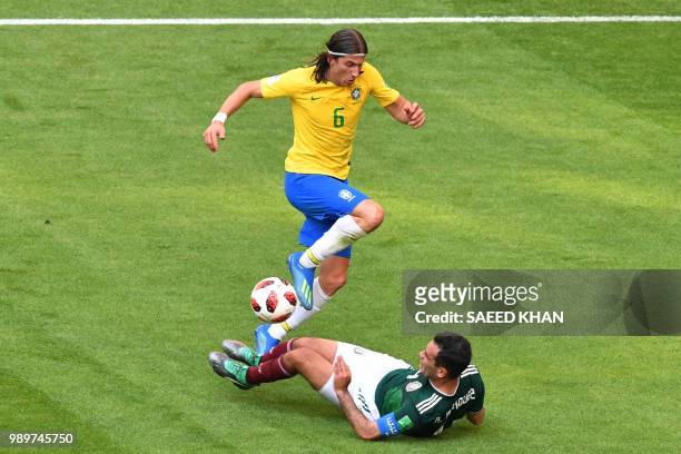 Brazil's defender Filipe Luis jumps over Mexico's midfielder Rafael Marquez during the Russia 2018 World Cup round of 16 football match between...