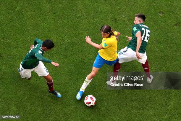 Filipe Luis of Brazil is challenged by Hector Herrera and Hugo Ayala of Mexico during the 2018 FIFA World Cup Russia Round of 16 match between Brazil...