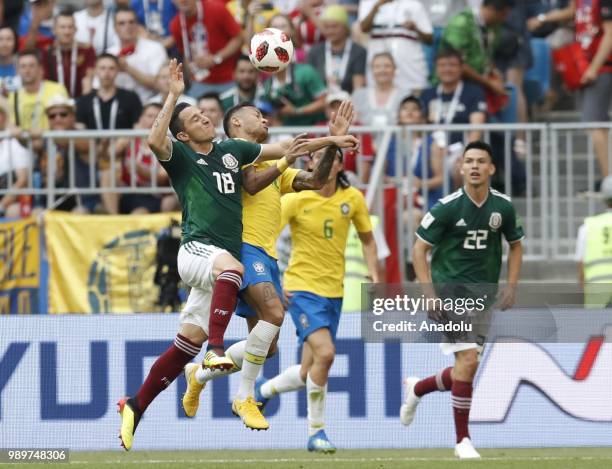 Neymar of Brazil in action against Hirving Lozano and Andres Guardado of Mexico during the 2018 FIFA World Cup Russia Round of 16 match between...