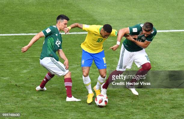 Neymar Jr of Brazil is challenged by Hirving Lozano of Mexico and Hector Herrera of Mexico during the 2018 FIFA World Cup Russia Round of 16 match...