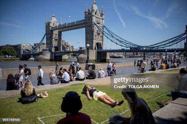 Woman takes a nap in the sunshine at Potters Fields Park near Tower Bridge in central London on July 2 as the country basks in a hot summer spell.