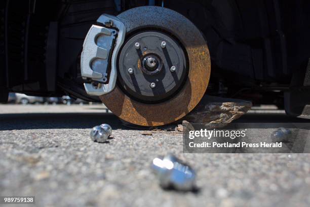 Lug nuts rest on the ground next to a Lexus RX 350 luxury SUV at Berlin City Auto Group in Portland on Monday, June 26, 2018. Rims were stolen from...