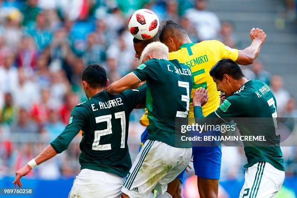 Brazil's midfielder Casemiro heads the ball as he vies with Mexico's defender Carlos Salcedo during the Russia 2018 World Cup round of 16 football...