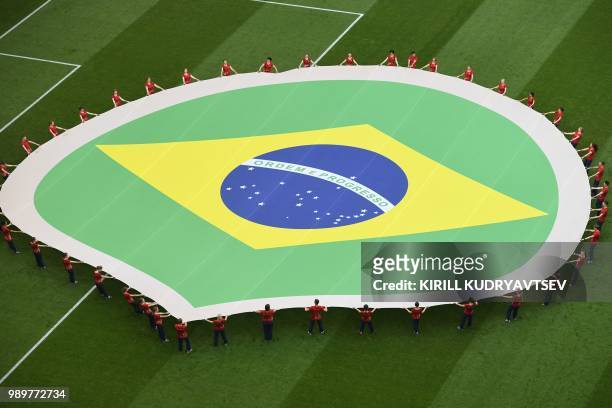 The Brazilian flag is unfolded on the pitch before the Russia 2018 World Cup round of 16 football match between Brazil and Mexico at the Samara Arena...