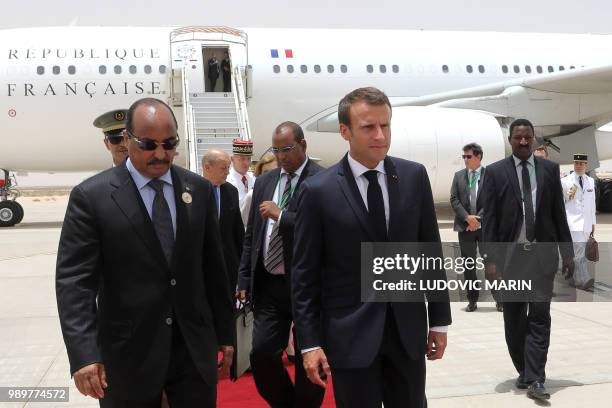 Mauritania President Mohamed Ould Abdel Aziz welcomes French President Emmanuel Macron upon his arrival at Nouakchott on July 2, 2018. - Macron,...
