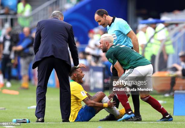 Miguel Layun of Mexico collects the ball as Neymar Jr of Brazil goes down injured during the 2018 FIFA World Cup Russia Round of 16 match between...