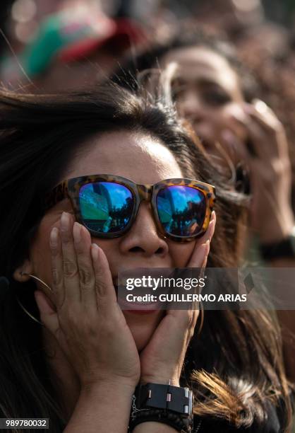 Fan of Mexico watches the World Cup football match between Mexico and Brazil during a public event at the Angel de la Independencia Monument in...