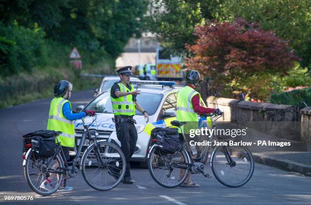 Cyclists turned away at the police cordon on Ardbeg Road on the Isle of Bute in Scotland, after officers found the body of a young girl on the site...