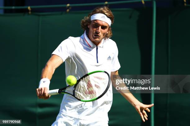 Stefanos Tsitsipas of Greece returns against Gregoire Barrere of France during their Men's Singles first round match on day one of the Wimbledon Lawn...