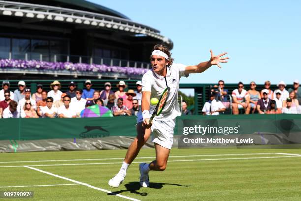 Stefanos Tsitsipas of Greece returns against Gregoire Barrere of France during their Men's Singles first round match on day one of the Wimbledon Lawn...