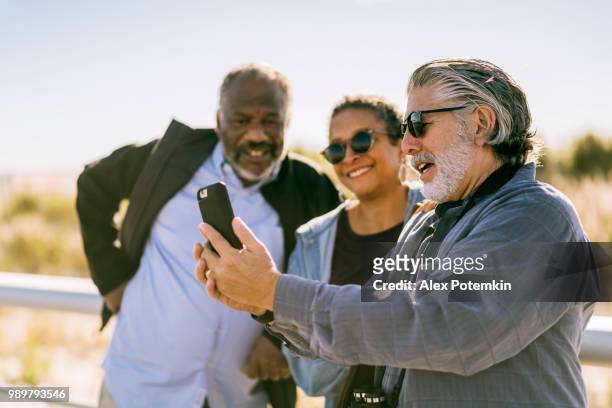 senioren freunde nehmen selfie am strand - alex potemkin or krakozawr stock-fotos und bilder