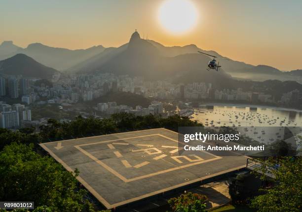 a helicopter coming in to land on sugarloaf mountain, rio de janeiro, brazil. - hubschrauber landeplatz stock-fotos und bilder