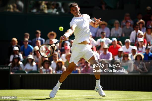 Grigor Dimitrov of Bulgaria returns against Stanislas Wawrinka of Switzerland during their Men's Singles first round match on day one of the...