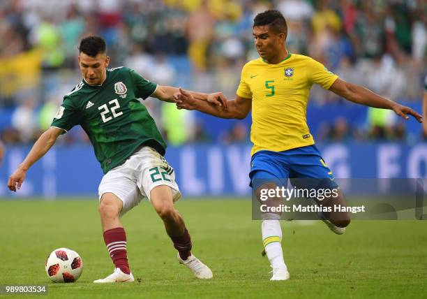 Hirving Lozano of Mexico and Casemiro of Brazil compete for the ball during the 2018 FIFA World Cup Russia Round of 16 match between Brazil and...