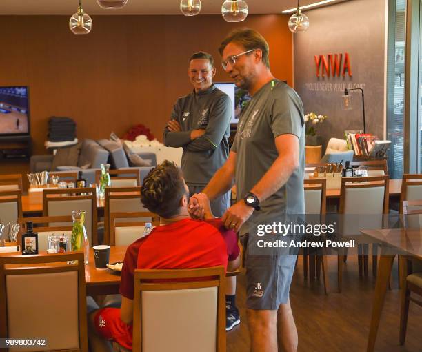 Jurgen Klopp manager of Liverpool with Adam Lallana during their first day back for pre-season training at Melwood Training Ground on July 2, 2018 in...