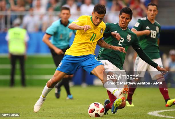 Philippe Coutinho of Brazil battles for the ball with Hugo Ayala of Mexico during the 2018 FIFA World Cup Russia Round of 16 match between Brazil and...