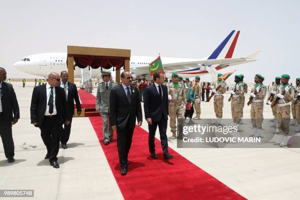 Mauritania President Mohamed Ould Abdel Aziz and French President Emmanuel Macron walk past the honour guard during a welcoming ceremony upon his...