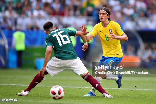 Filipe Luis of Brazil is challenged by Hector Herrera of Mexico during the 2018 FIFA World Cup Russia Round of 16 match between Brazil and Mexico at...