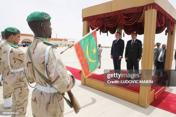 French President Emmanuel Macron and the Mauritania President Mohamed Ould Abdel Aziz listen to the national anthem during a welcoming ceremony at...