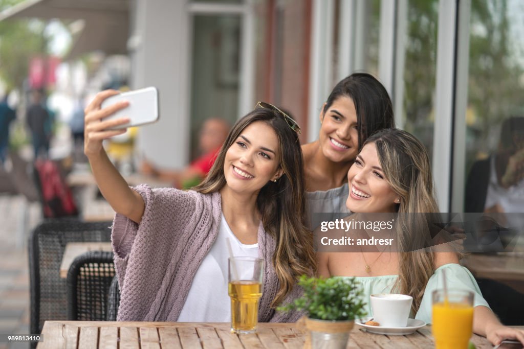 Beautiful women taking a selfie at an outdoor restaurant