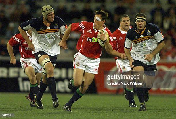 Mark Taylor of the British and Irish Lions is pursued by Daniel Vickerman and Angus Cott of the ACT Brumbies during the match between the British and...