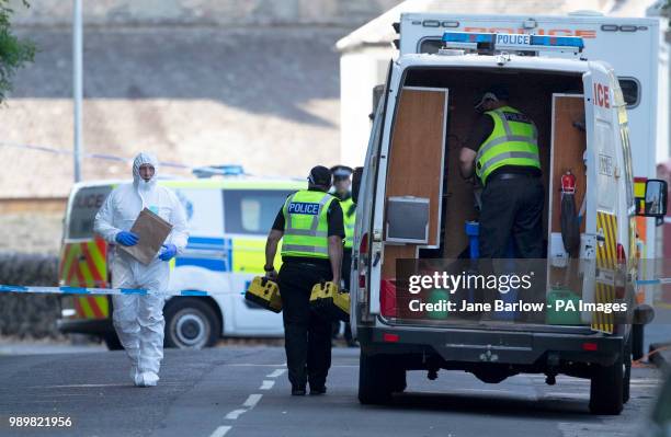 Forensic officers at the police cordon on Ardbeg Road on the Isle of Bute in Scotland, after officers found the body of a young girl on the site of...