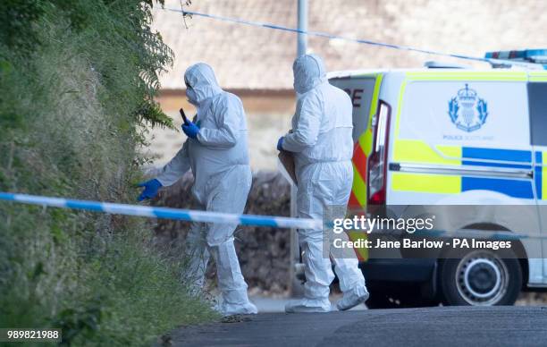 Forensic officers at the police cordon on Ardbeg Road on the Isle of Bute in Scotland, after officers found the body of a young girl on the site of...