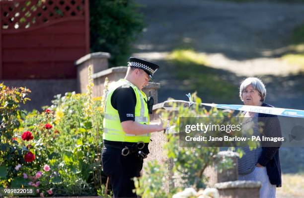Police speak to locals Ardbeg Road on the Isle of Bute in Scotland, after officers found the body of a young girl on the site of the former Cames...