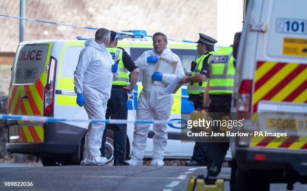 Forensic officers at the police cordon on Ardbeg Road on the Isle of Bute in Scotland, after officers found the body of a young girl on the site of...
