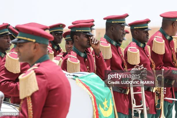 Members of the Mauritanian military brass band wait on the tarmac for the arrival of the French President to Nouakchott airport where he will later...