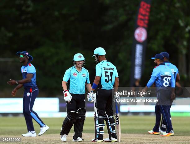 David Warner of Winnipeg Hawks talks to teammate Lendl Simmons during a Global T20 Canada match against Toronto Nationals at Maple Leaf Cricket Club...