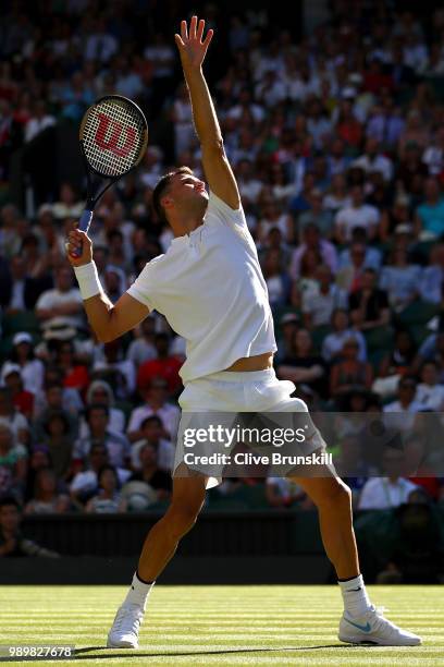 Grigor Dimitrov of Bulgaria serves against Stanislas Wawrinka of Switzerland during their Men's Singles first round match on day one of the Wimbledon...