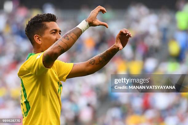 Brazil's forward Roberto Firmino gestures as he celebrates after scoring a goal during the Russia 2018 World Cup round of 16 football match between...