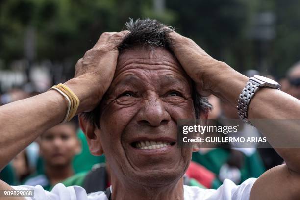 Fan of Mexico reacts as he watches the World Cup football match between Mexico and Brazil during a public event at the Angel de la Independencia...