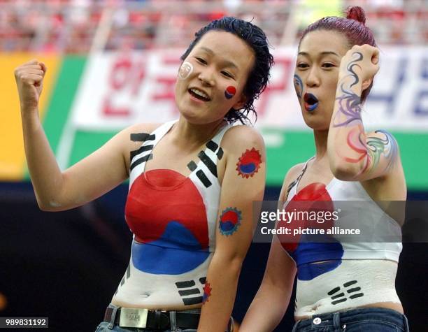 Two South Korean soccer fanatics, who have confidence in their team's abilities, flex their muscles for the photographers. Sceptics could have...