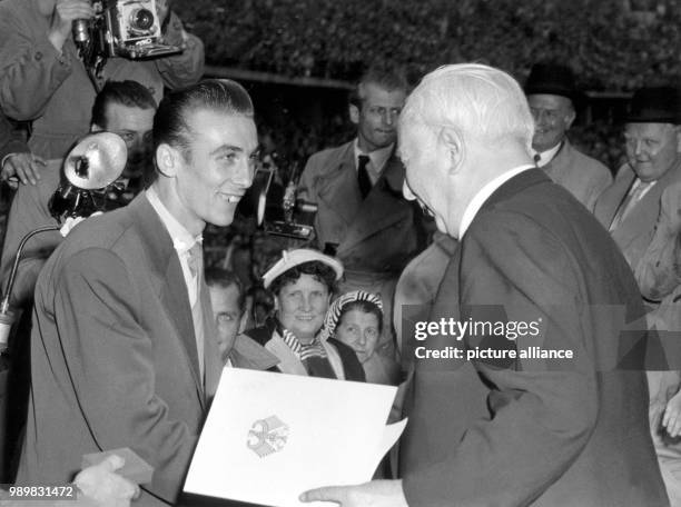 President Theodor Heuss hands the "Silver Bay Leaf" to soccer player Horst Eckel . The 1954 World Cup champions were honoured by the president along...