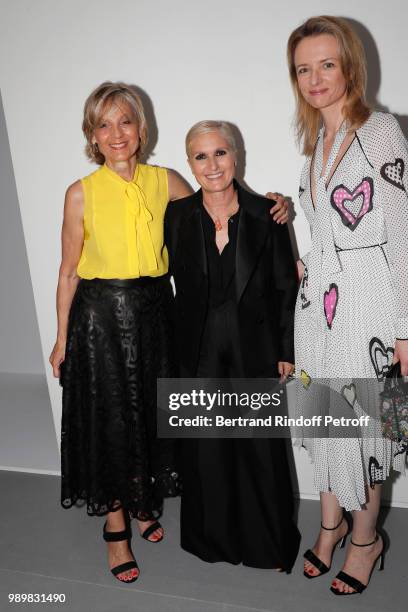 Stylist Maria Grazia Chiuri standing between Louis Vuitton's executive vice president Delphine Arnault and her mother Helene Arnault pose after the...