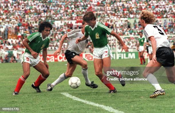 German defenders Andreas Brehme and Karlheinz Foerster try to stop advancing Mexican players Hugo Sanchez and Miguel Espana . The German national...