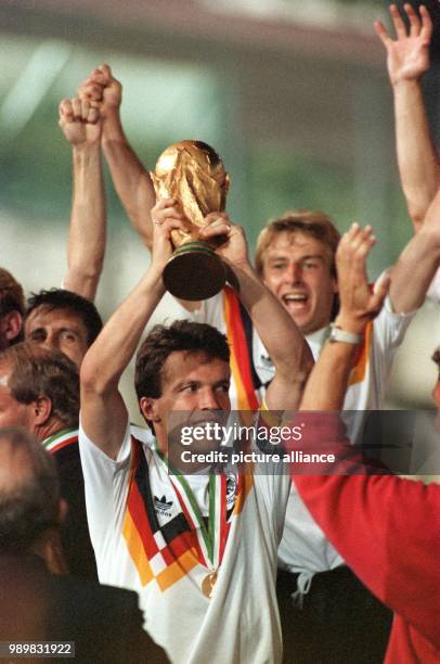 German team captain Lothar Matthaeus lifts up the World Cup triumphantly at the presentation ceremony for his team at Olympic Stadium in Rome, Italy...