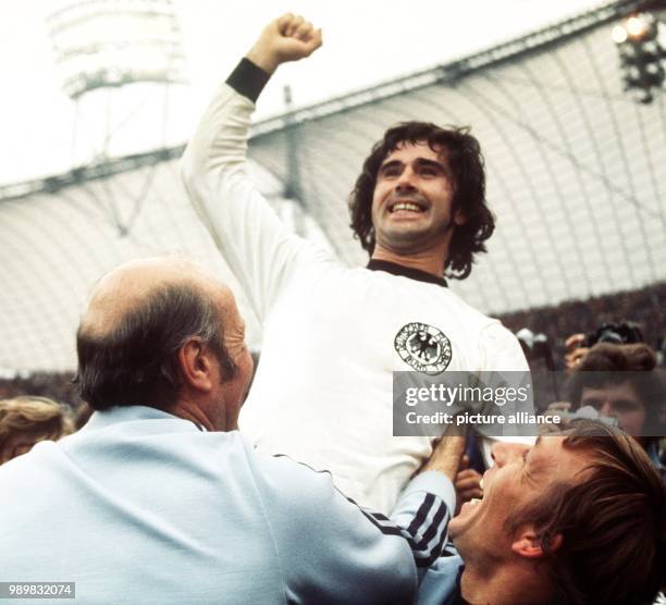 After the final whistle German forward Gerd Mueller raises his right fist in triumph. Coach Helmut Schoen joins the celebration. After numerous...