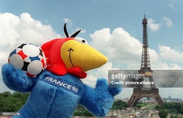 The 1998 FIFA World Cup mascot "Footix" is posing in front of the Eiffel Tower in Paris, holding a ball in the colors of the Tricolore, picture taken...