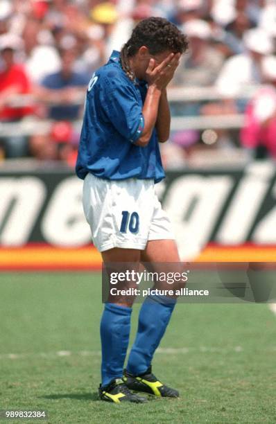 Italian midfielder Roberto Baggio covers his face with his hands after failing to score the deciding goal in the penalty shoot out during the 1994...