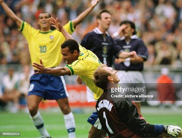 Brazilian defender Cafu and midfielder Rivaldo cheer after scoring the 2-1 goal, while Scotish goalkeeper Jim Leighton kneels defeated on the pitch...