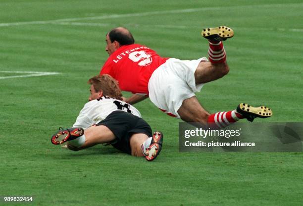 Bulgarian midfielder Yordan Letchkov manages to catch the cross ball with a header before German midfielder Thomas Haessler can get to it and scores...