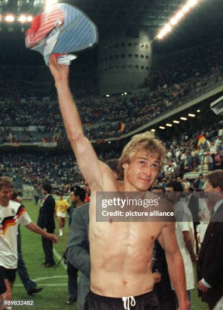 German forward Juergen Klinsmann is topless and holds up his tricot, smiles and waves with it towards the spectators after the finall whistle at the...