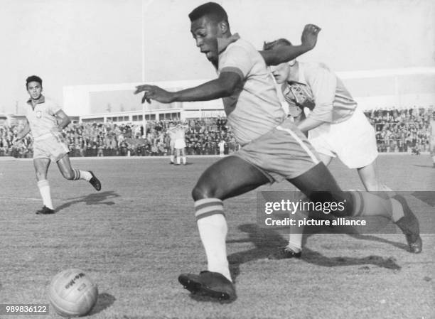 Brazilian striker Pele runs with the ball past a Swedish defender of the Malmoe FF soccer club during an international friendly between Malmoe FF and...