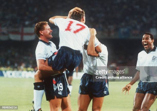 The English players midfield mastermind Paul Gascoigne lifts up David Platt , who scored the 1-0 goal and John Barnes who joins the celebration with...