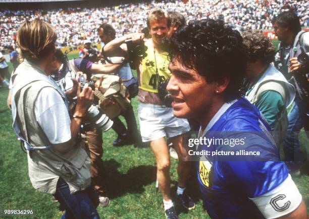 Exhausted but happy Argentinian captain and midfield mastermind Diego Armando Maradona walks through a group of photographers. On the way to the...