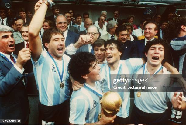 Argentine midfield mastermind Diego Armando Maradona holds the World Cup trophy in his hands and celebrates Argentina's second ever World Cup title...